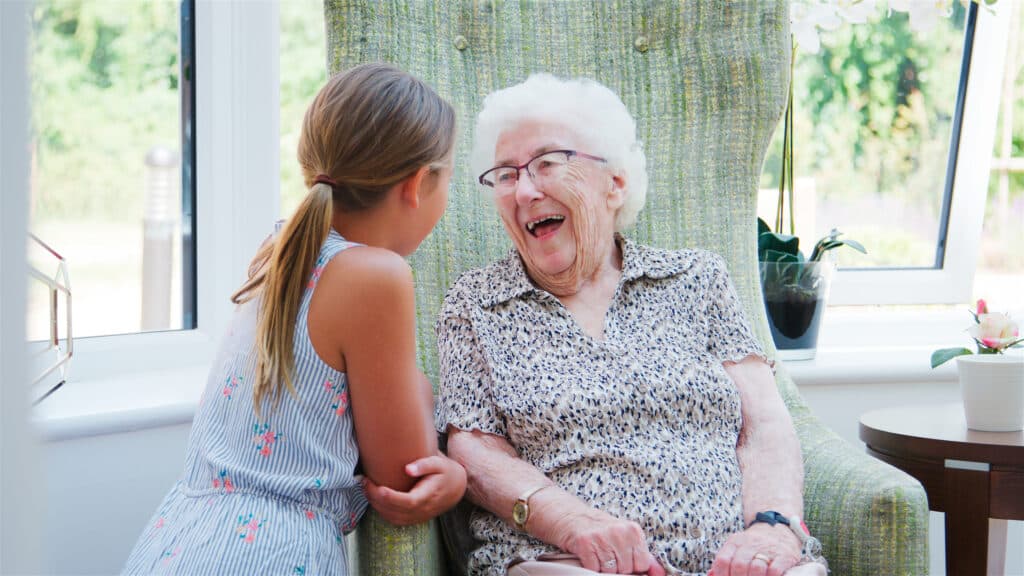Oma en kleindochter lachend met elkaar in gesprek