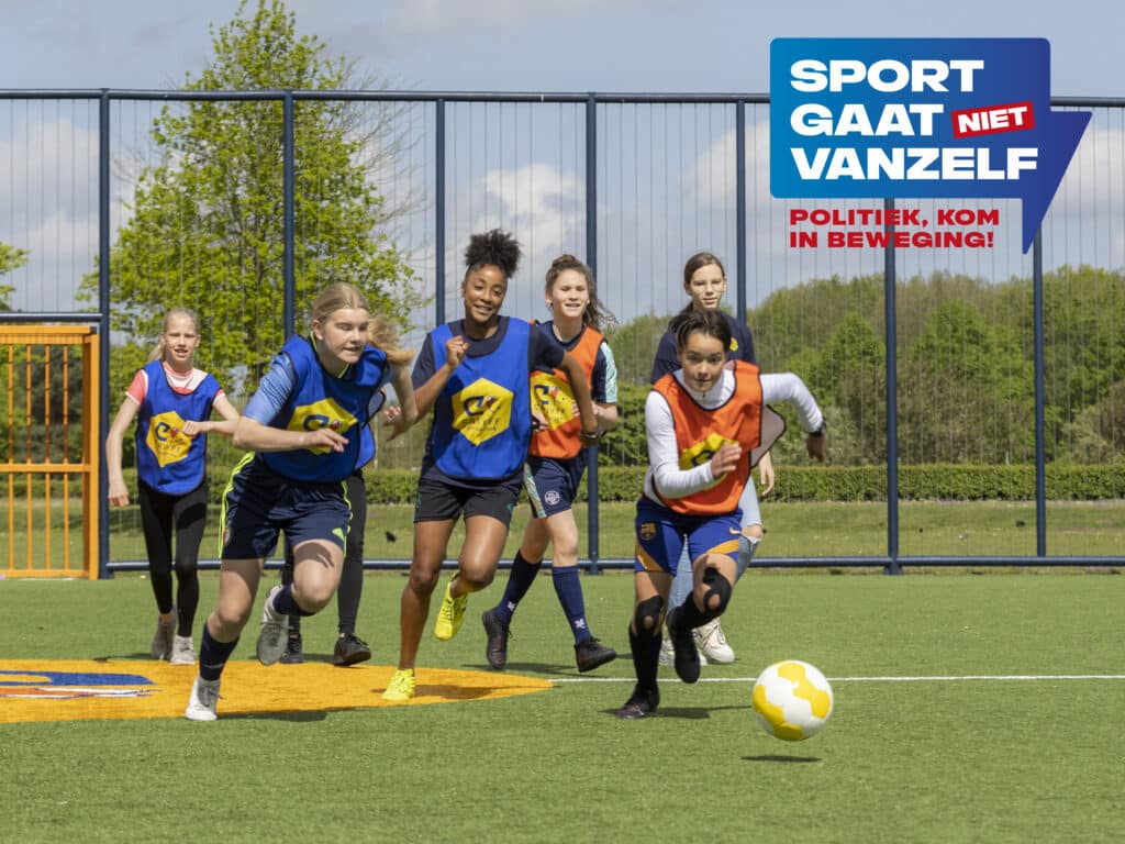 6 kinderen met een leeftijd rond de 12 in sportkleding op een voebalveld. Ze rennen richting een voetbal. Op de afbeelding staat de tekst Sport gaat niet vanzelf